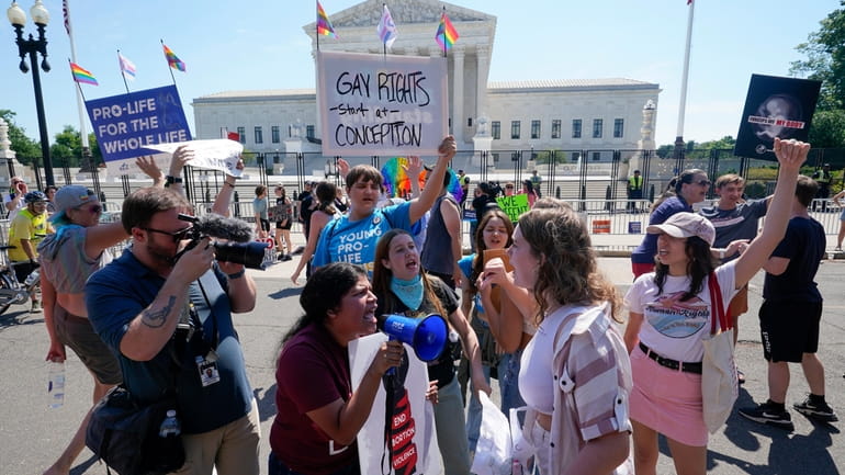 Anti-abortion demonstrators, center left, argue with abortion-rights activists outside the...