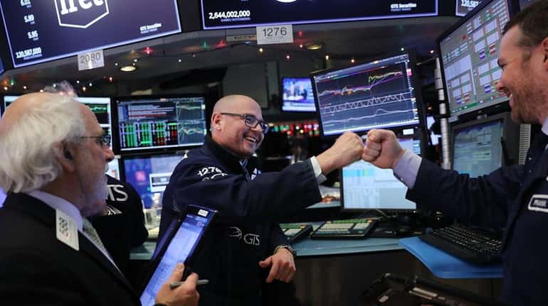 Traders work on the floor of the NYSE on Monday,...