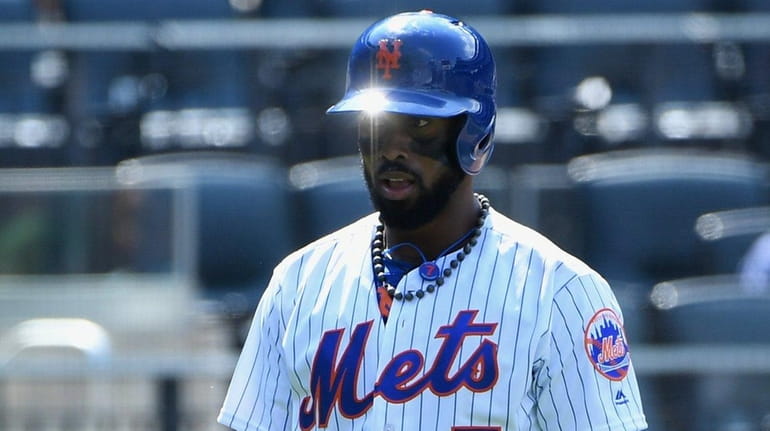 Mets' Jose Reyes returns to the dugout after he struck...