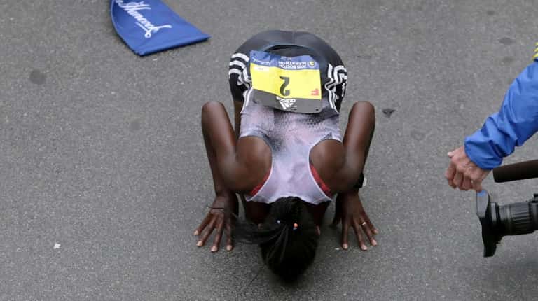Worknesh Degefa, of Ethiopia, kisses the ground after winning the...
