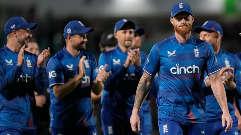 England players applaud England's Ben Stokes, right, as they leave...