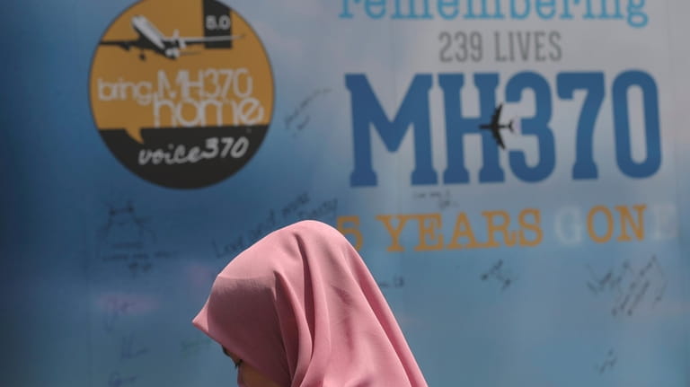A girl stands in front of a condolence message board...
