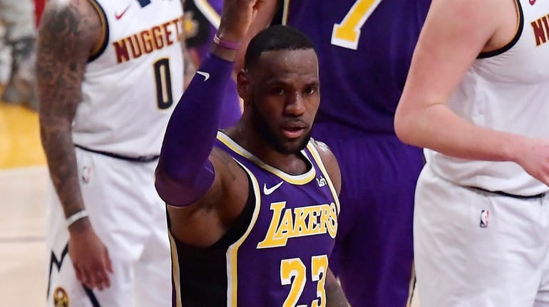 Lakers forward LeBron James gestures after scoring against the Nuggets...