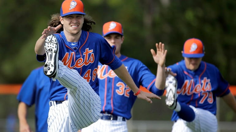 Mets pitcher Jacob deGrom stretches at the start of spring...