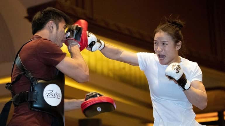 UFC women's strawweight champion Zhang Weili, right, of China, works...