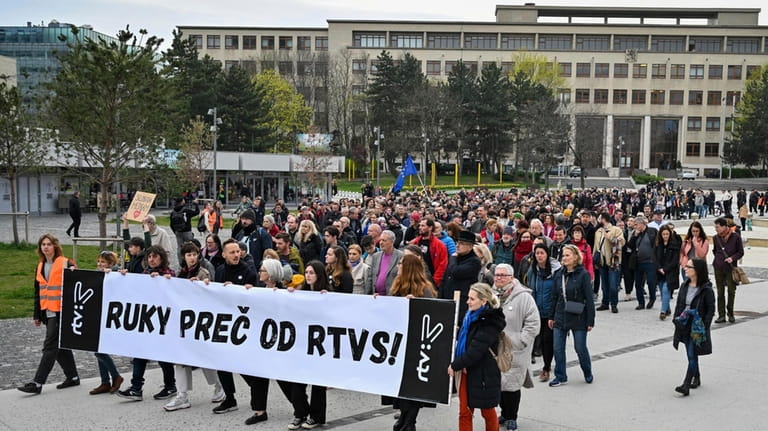 People hold a banner reading "Hands off rtvs (Slovakian public...