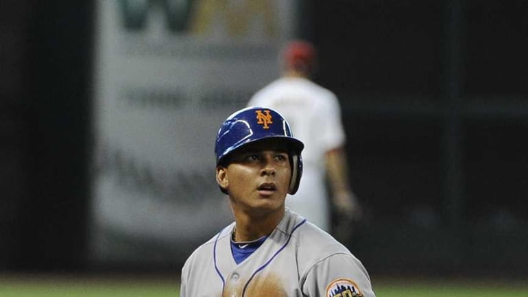 New York Mets' Ruben Tejada looks toward the umpire after...