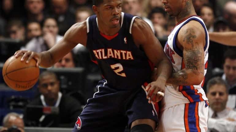 The Hawks' Joe Johnson works against the Knicks' Wilson Chandler...