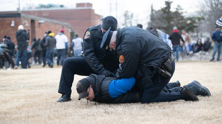 Suffolk County police officers arrest a Back the Blue protester...