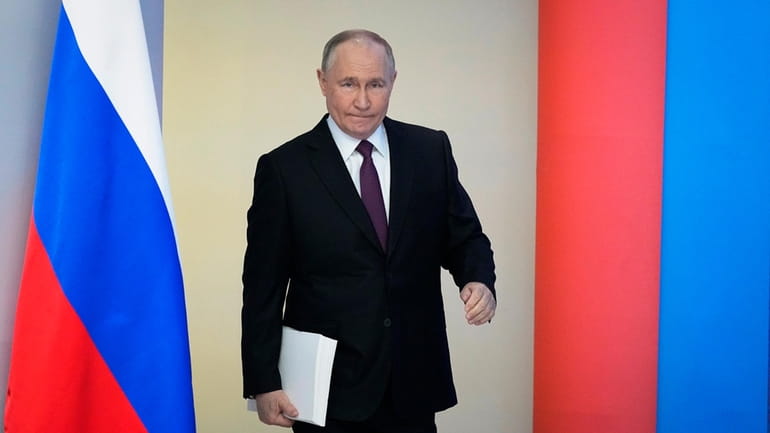 Russian President Vladimir Putin enters a hall to deliver his...