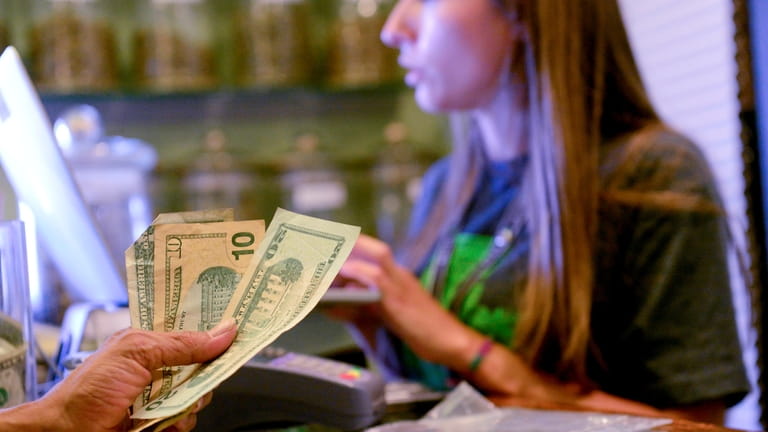 In Colorado, a medical marijuana customer counts out cash for a...