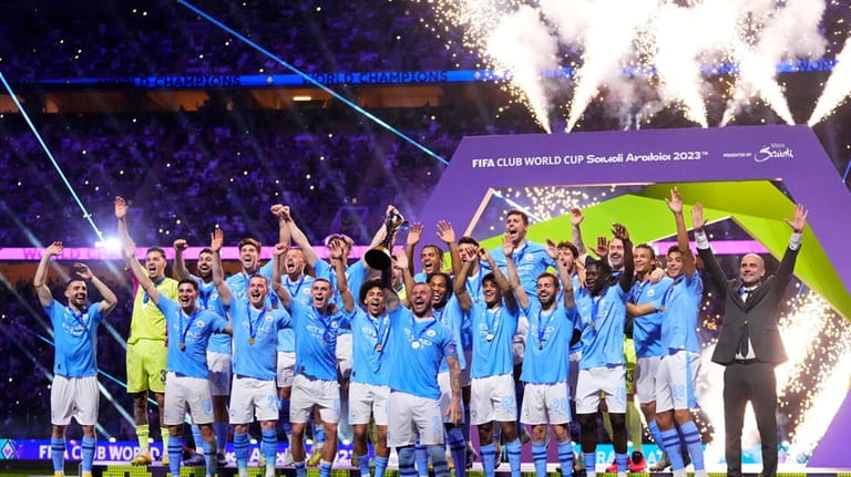 Manchester City's Kyle Walker, center, lifts the trophy at the...