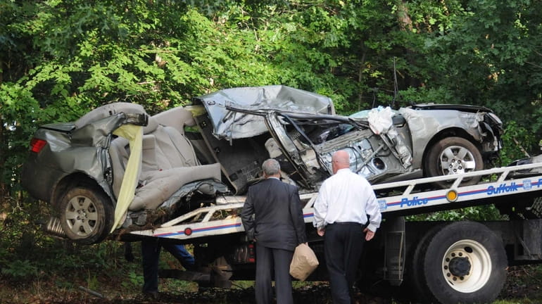 Detectives inspect the Hyundai Sonata that hit trees and a...