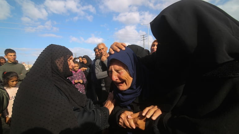 Palestinians mourn during the funeral of their relatives killed in...