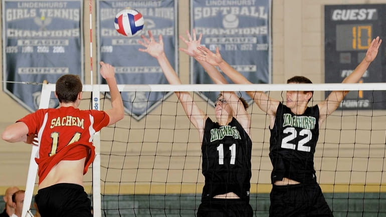 Lindenhurst's Chris DeLucie, center, and Dylan Claud, right, attempt to...