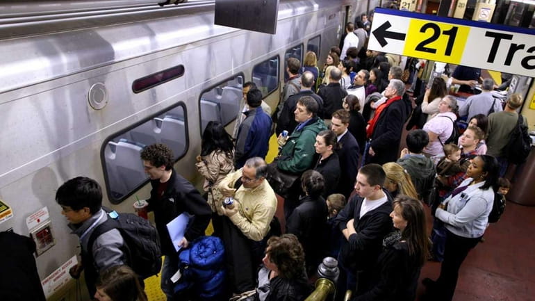 Passengers get ready to squeeze onto a train at Penn...
