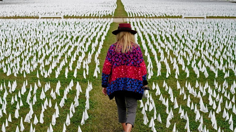Artist Suzanne Brennan Firstenberg walks among thousands of white flags...