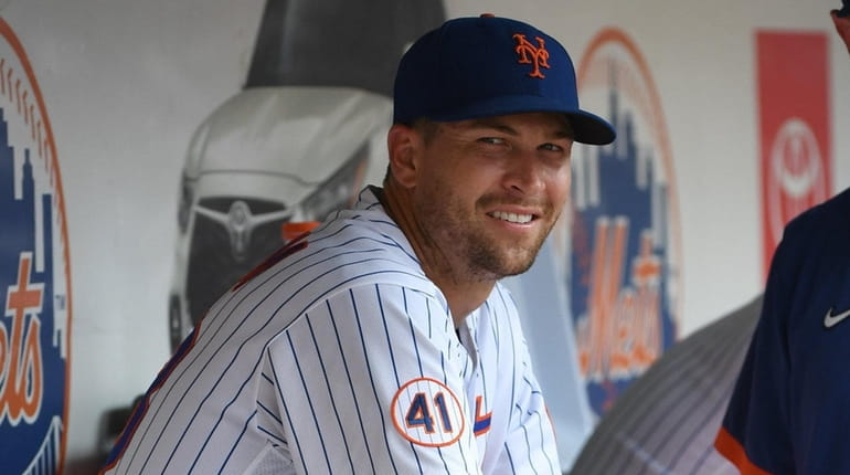 Mets starting pitcher Jacob deGrom smiles in the dugout after...