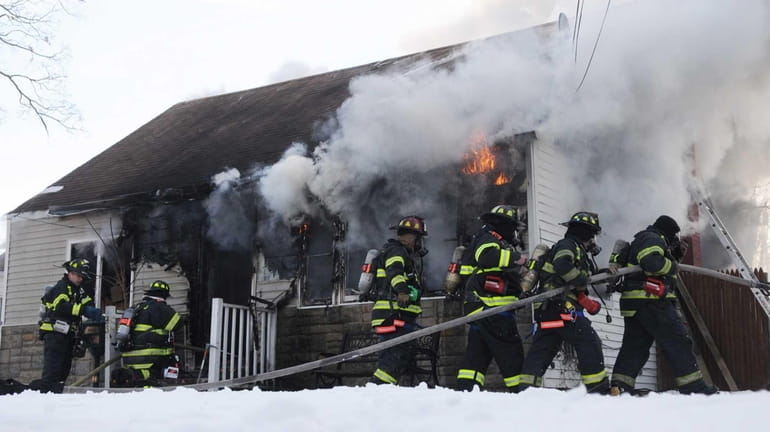 Firefighters battle a fire at a home on Storey Avenue...
