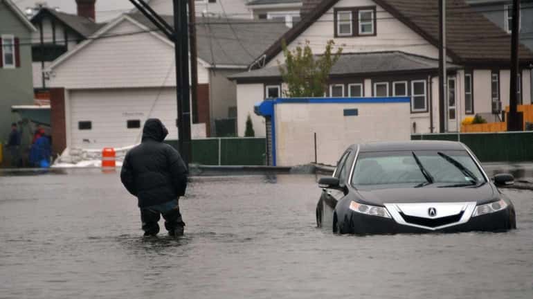 A man passes a submerged vehicle at the Oyster Bay...
