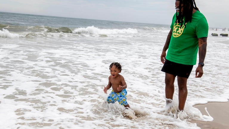 Daylan Gentry enjoys the water at Ocean Beach with his father,...