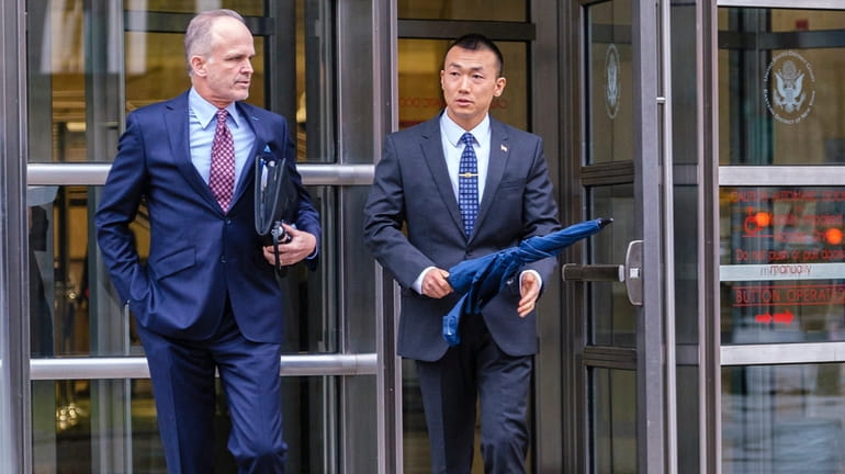 NYPD Officer Baimadajie Angwang, right, and his attorney, John Carman, leave...