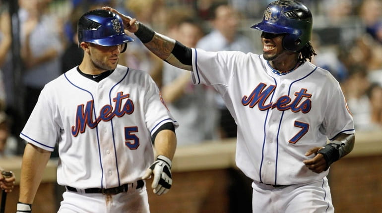 Mets shortstop Jose Reyes greets David Wright after they scored on...