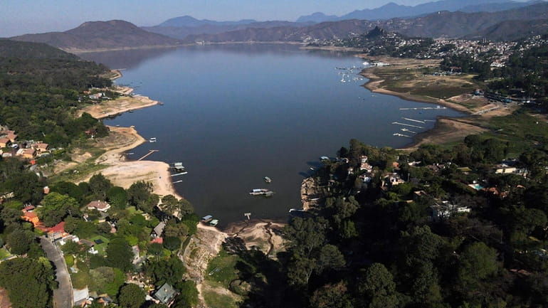 The banks of the Miguel Aleman dam lie exposed due...