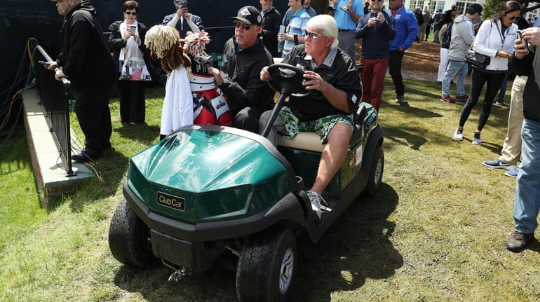 John Daly drives a golf cart during a practice round...