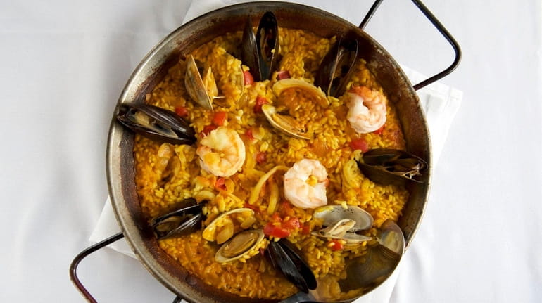 Seafood paella includes mussels, clams, shrimp, lobster and calamari at...