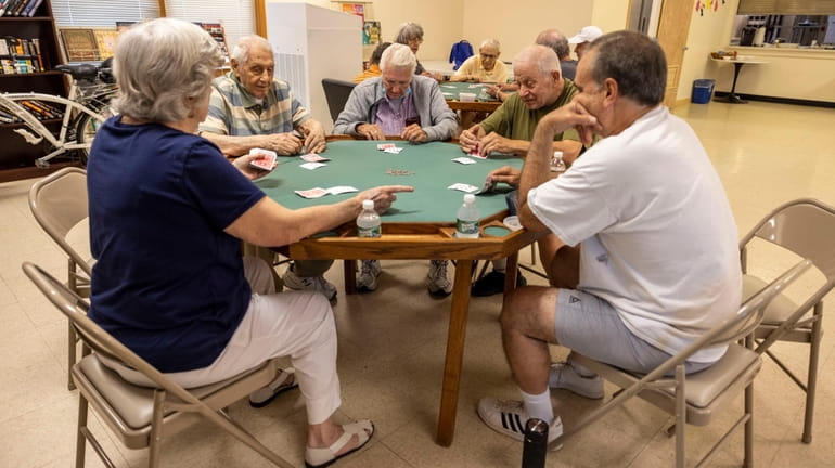 Senior citizens playing cards and staying cool inside the Merrick...