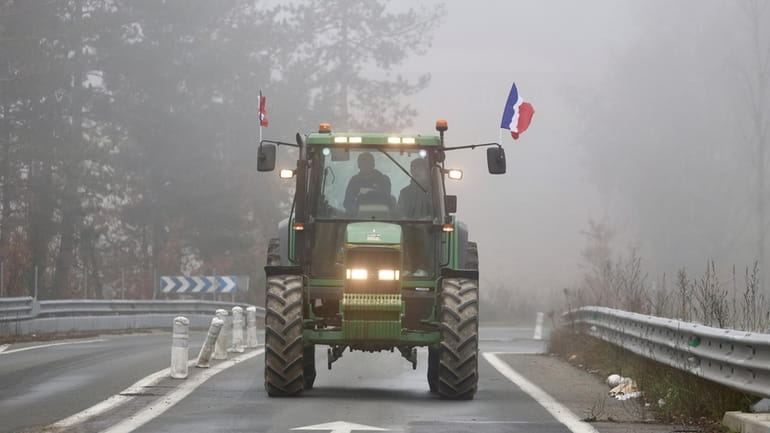 A farmer drives his tractor on a highway, near Agen,...