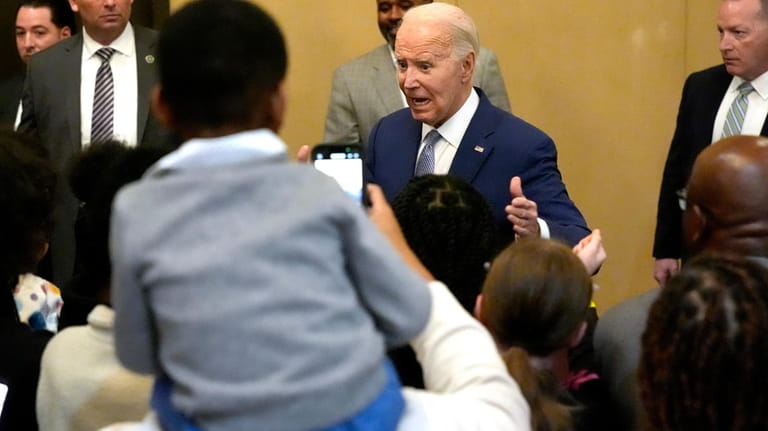 President Joe Biden greets attendees at the "Sunday Lunch" event...