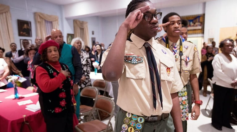 Jared Gordon, of Westbury, salutes with fellow Boy Scout Troop...
