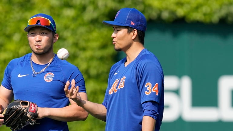 Chicago Cubs' Seiya Suzuki, left, and Mets pitcher Kodai Senga chat...