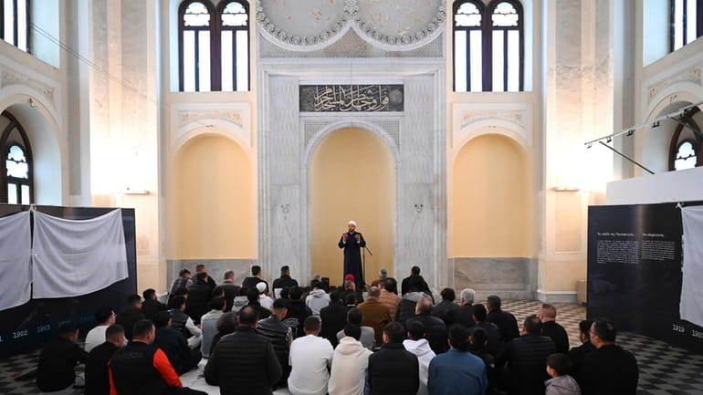 The imam leads the morning prayers at the historic Yeni...