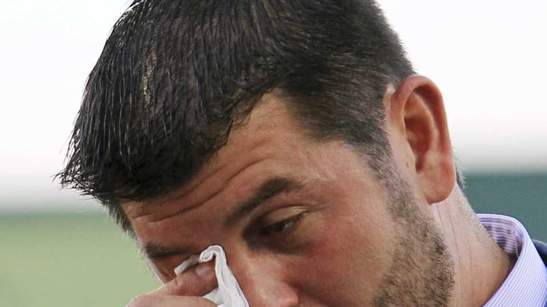 Boston Red Sox catcher Jason Varitek wipes a tear during...
