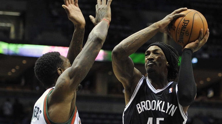Milwaukee Bucks' Larry Sanders left, defends as Brooklyn Nets' Gerald...