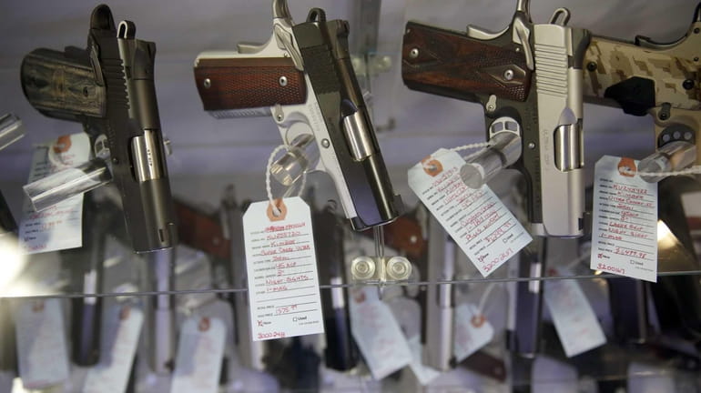 Handguns sit in a glass display case at Metro Shooting...