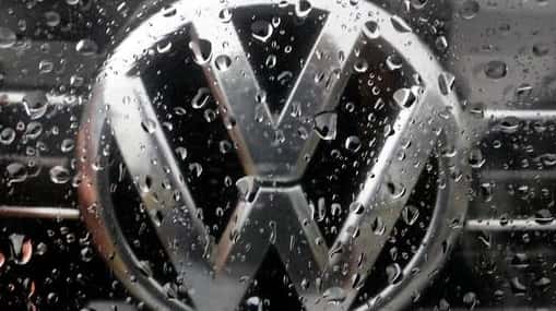 The Volkswagen logo is photographed through rain drops on a...