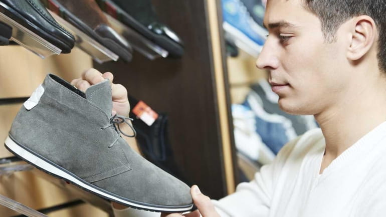 A man choosing shoes during footwear shopping at shoe shop