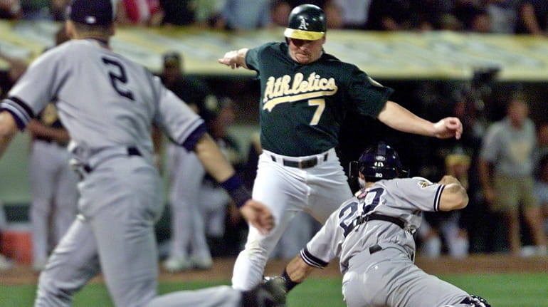 Oakland Athletics' Jeremy Giambi, center, is tagged out at home...