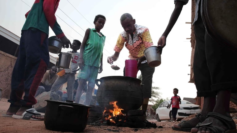 People prepare food in a Khrtoum neighborhood on June 16,...