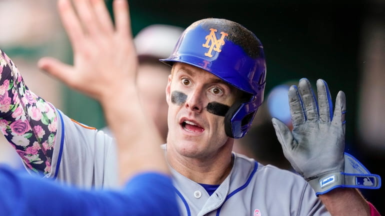 Mets' Mark Canha celebrates scoring during the fifth inning of...