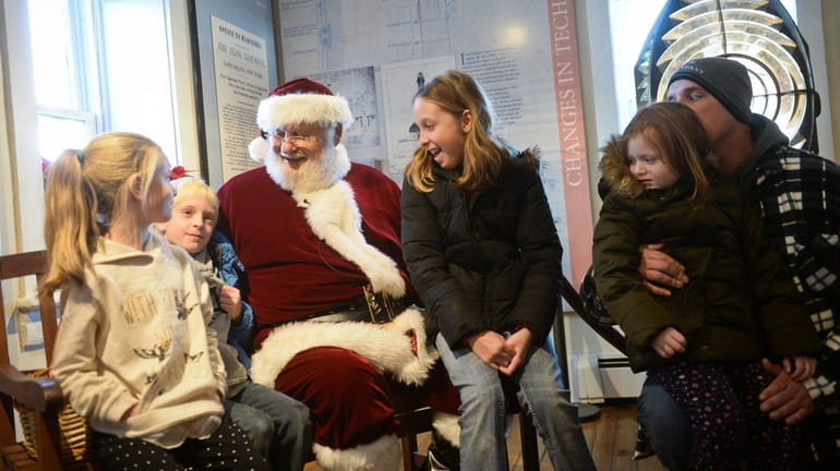 Santa greets, from left, Brianna Sipel, 7, of Huntington, Evan...