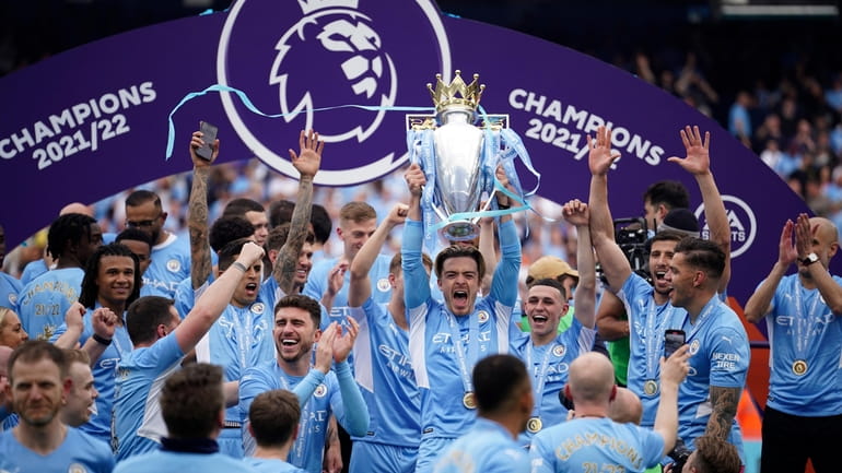 FILE - Manchester City players celebrate with trophy after winning...