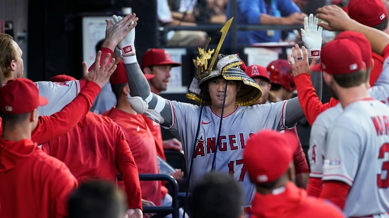Los Angeles Angels' Shohei Ohtani is congratulated in the dugout...