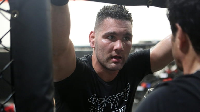 Chris Weidman receives instruction from trainer Ray Longo in between...