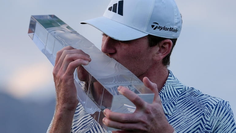 Nick Dunlap kisses the trophy after winning the American Express...