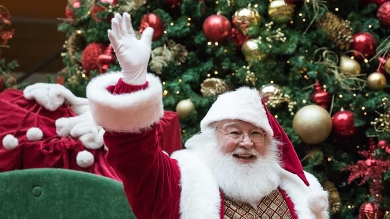 Santa Claus waves to children at the Toys for Tots...